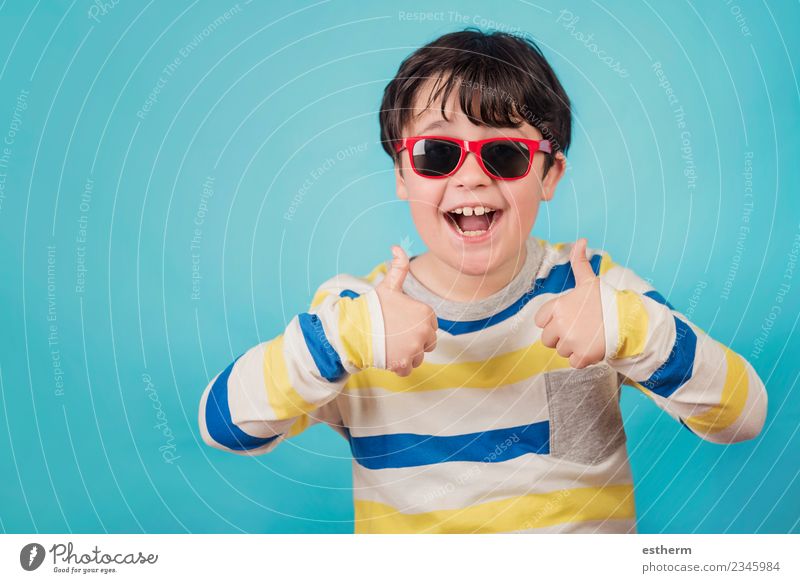 smiling boy with sunglasses on blue background Lifestyle Joy Party Event Feasts & Celebrations Human being Masculine Child Toddler Boy (child) Infancy 1