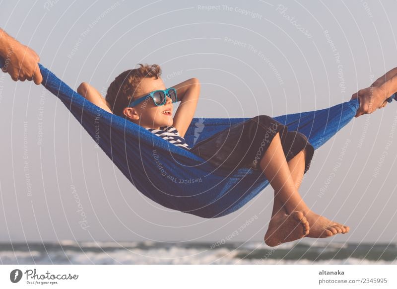 Happy little boy relaxing on the beach at the day time. Lifestyle Joy Relaxation Leisure and hobbies Playing Vacation & Travel Trip Adventure Freedom Summer Sun