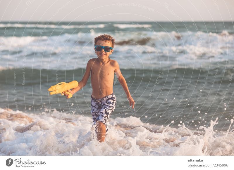 Happy little boy relaxing on the beach at the day time. Lifestyle Joy Beautiful Relaxation Leisure and hobbies Playing Vacation & Travel Trip Adventure Freedom