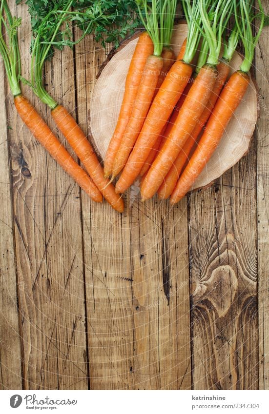 Fresh raw carrots with leaves on a wooden table Vegetable Nutrition Vegetarian diet Leaf Brown Green Carrot Farmer food Harvest healthy market orange Organic