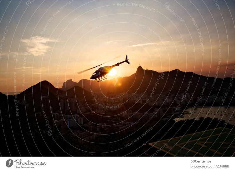 A helicopter flows into the sunset in Rio de Janeiro Landscape Beautiful weather Mountain Brazil Capital city Port City Skyline Tourist Attraction Landmark
