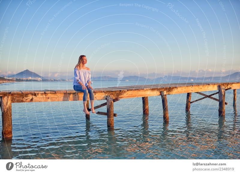 Barefoot woman sitting on a coastal pier at sunset Lifestyle Happy Beautiful Leisure and hobbies Vacation & Travel Freedom Summer Sun Beach Ocean Woman Adults