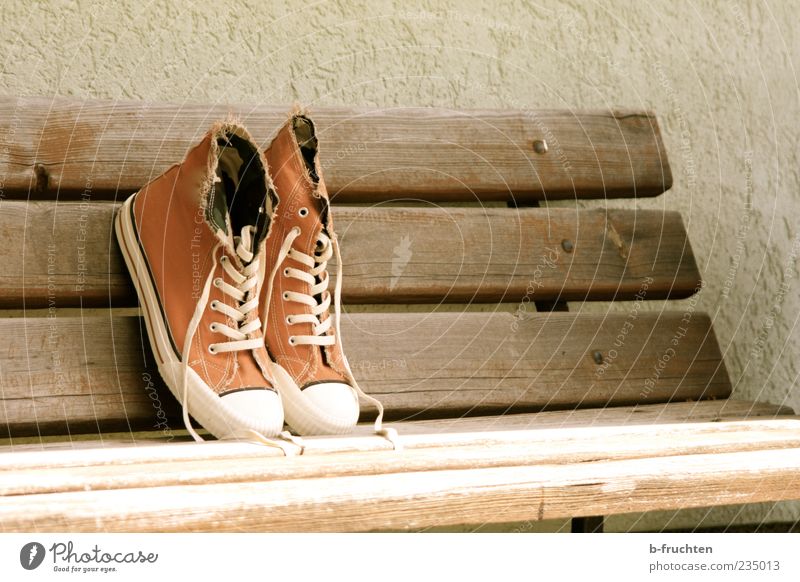 Cloth shoes on a park bench, antique look Design Wall (barrier) Wall (building) Footwear Sneakers cloth shoe Wood Old Dirty Brown Loneliness lace-up shoe