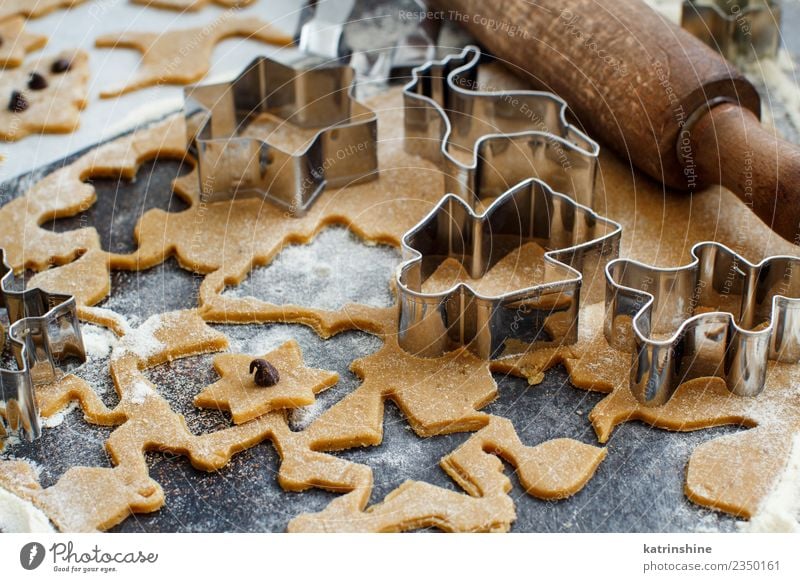 Cooking Christmas cookies with cookie cutters on a dark table Dough Baked goods Dessert Winter Kitchen Metal Make Brown White Tradition Baking Bakery biscuit