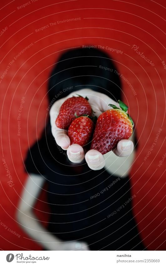 Young woman holding strawberries in her hand Food Fruit Strawberry Nutrition Eating Organic produce Vegetarian diet Lifestyle Design Human being Feminine