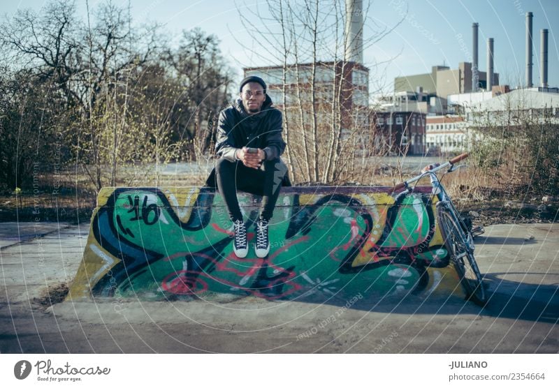 Young modern hipster is sitting on a halfpipe at skatepark Modern Town City life Camera Ice-skating Skate park Lifestyle Hipster Skinny jeans Clothing Jacket