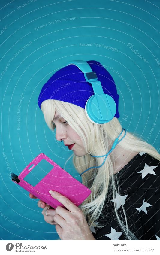 Young woman reading and listening to music with her phone Lifestyle Style Hair and hairstyles Leisure and hobbies Cellphone Headset Cable Technology