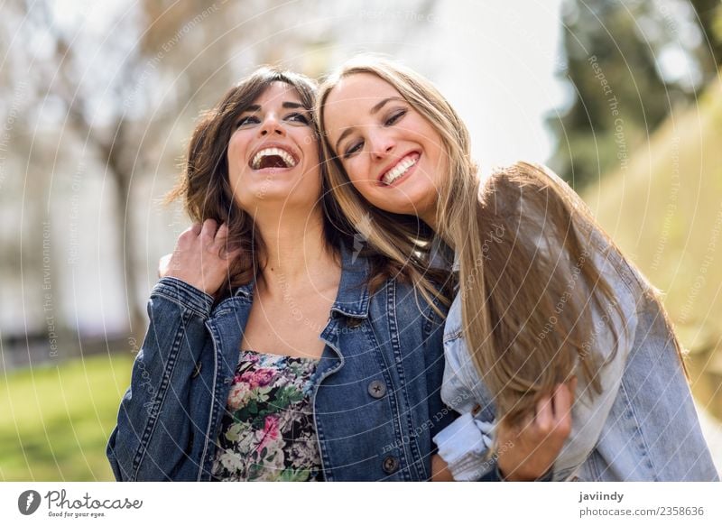 Two happy young women friends hugging in the street. Lifestyle Joy Human being Feminine Young woman Youth (Young adults) Woman Adults Friendship 2 18 - 30 years