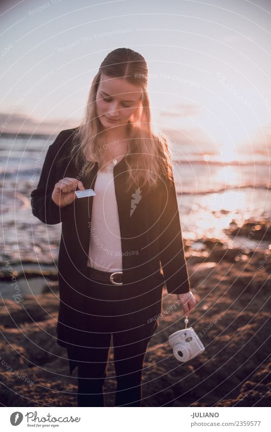 Young woman is looking at polaroid picture at the beach Beach Dusk Emotions Happy Life Lifestyle Spain Summer Sun Sunset Warmth Adventure Communicate Freedom