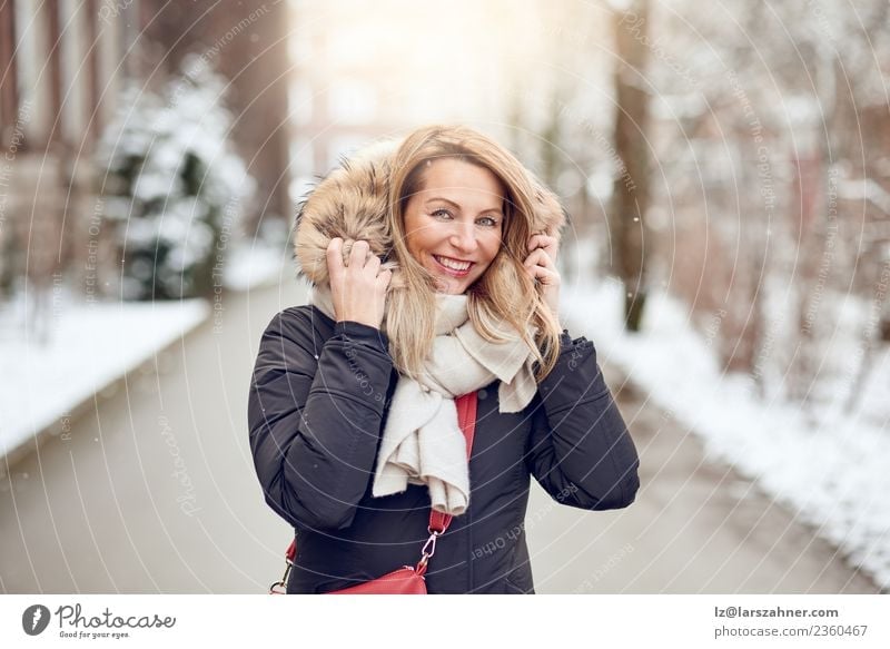 Friendly young blond woman outdoors in winter Lifestyle Happy Beautiful Face Winter Snow Woman Adults 1 Human being 45 - 60 years Park Street Fashion Coat