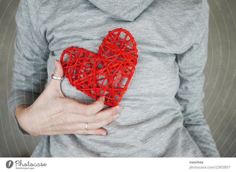 Young woman holding a red heart against her chest Design Healthy Health care Wellness Life Valentine's Day Mother's Day Human being Feminine