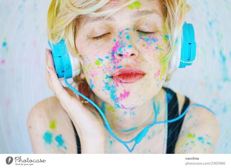 Young woman is listening to music with paint in her face Lifestyle Style Beautiful Wellness Leisure and hobbies Headset Technology Entertainment electronics