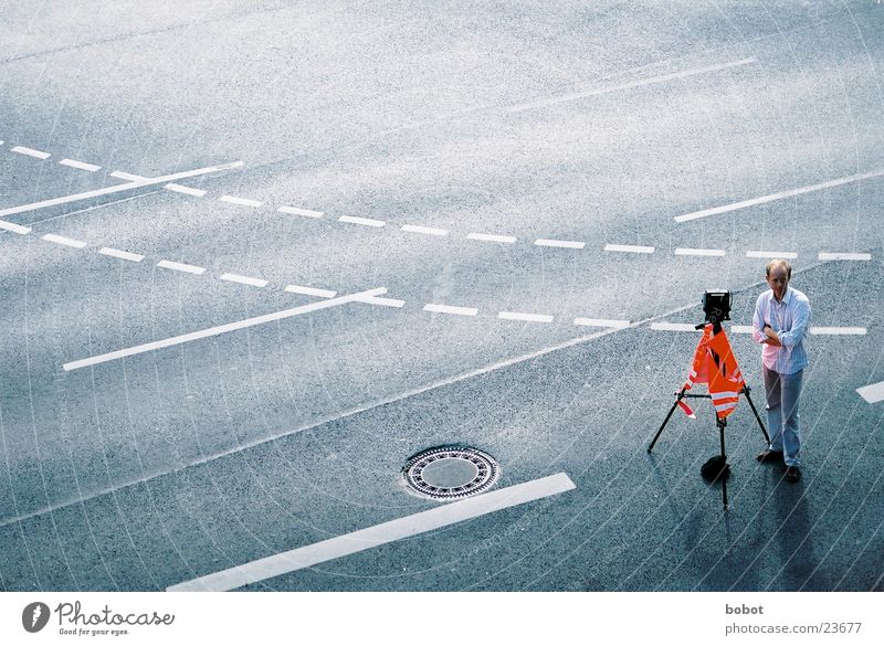 on the hunt Photographer Transport Asphalt Tar Take a photo Photography Three-legged Man Camera Street signal vest statif