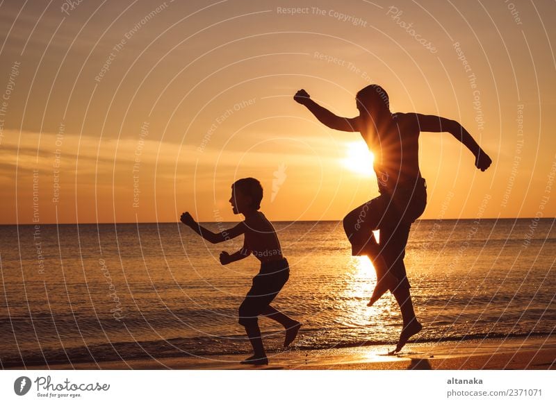 Father and son playing on the beach at the sunset time. Lifestyle Joy Happy Leisure and hobbies Vacation & Travel Trip Adventure Freedom Camping Summer Sun