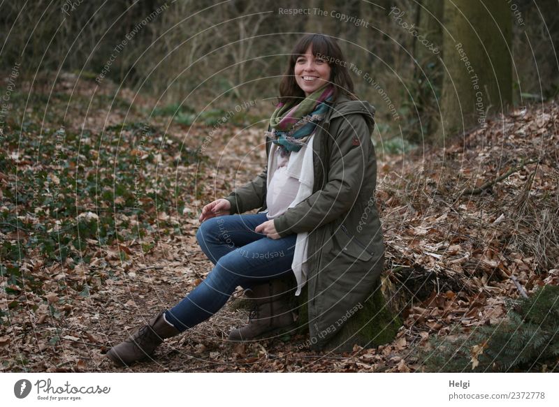 young pregnant woman with long hair sits smiling on a tree trunk in the forest Human being Feminine Young woman Youth (Young adults) Adults 1 30 - 45 years