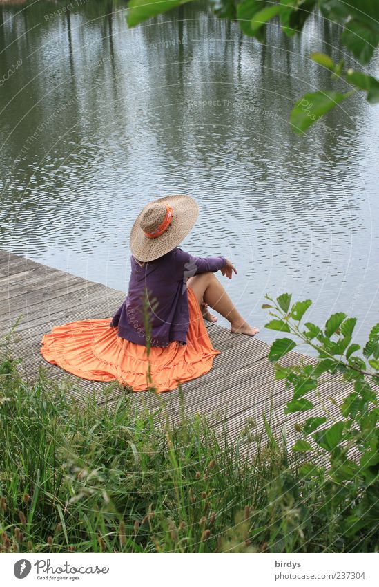 young barefoot dreamy woman with skirt and straw hat sits lasciviously on wooden pier by lake Young woman Feminine Elegant Lascivious Style Human being Water