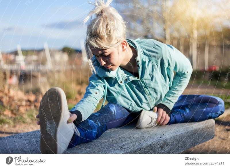 blonde woman sitting in the grass and stretching in a park Lifestyle Happy Beautiful Body Sports Human being Feminine Young woman Youth (Young adults) Woman