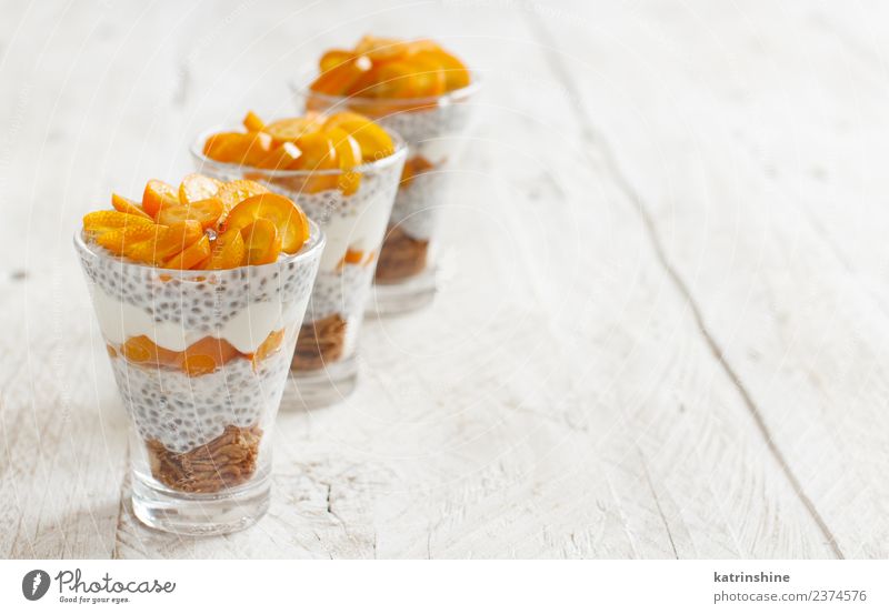Chia pudding parfait, layered with kumquat and granola Yoghurt Fruit Dessert Eating Breakfast Diet Bowl Spoon Bright White Colour Cereal chia Pudding seed Dairy