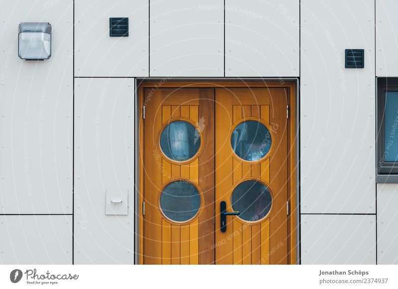 Door with round windows on white facade Wooden door front door outer door Round Peephole White Brown Modern Harbour Maritime Minimalistic geometric Architecture
