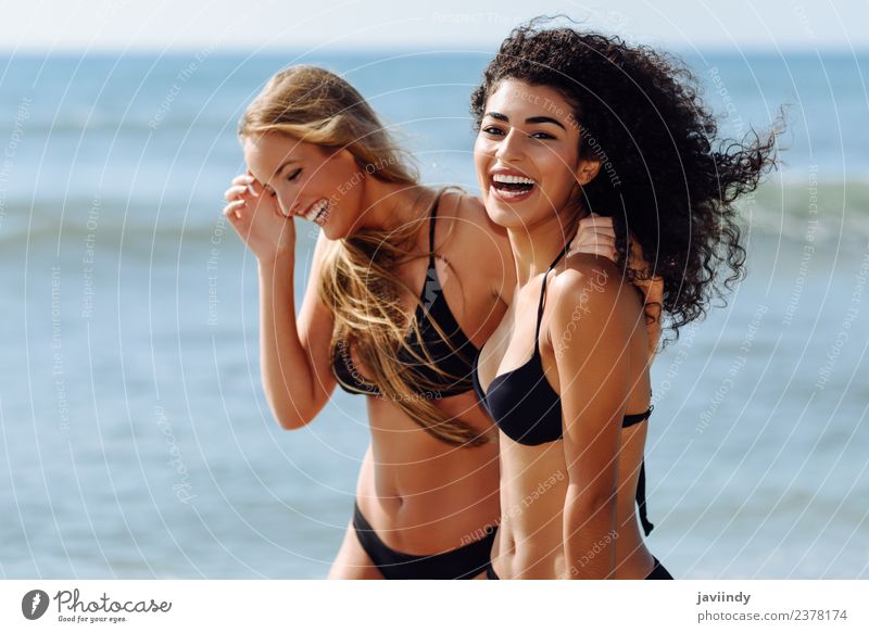 Smiling females wearing black bikini walking along the shore. Lifestyle Joy Hair and hairstyles Vacation & Travel Tourism Summer Beach Ocean Human being