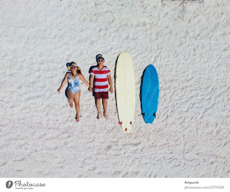Aerial view of a surfing couple laying on the beach aerial drone surfboards blue white sand relationship outdoors summer romance surfers extreme sports