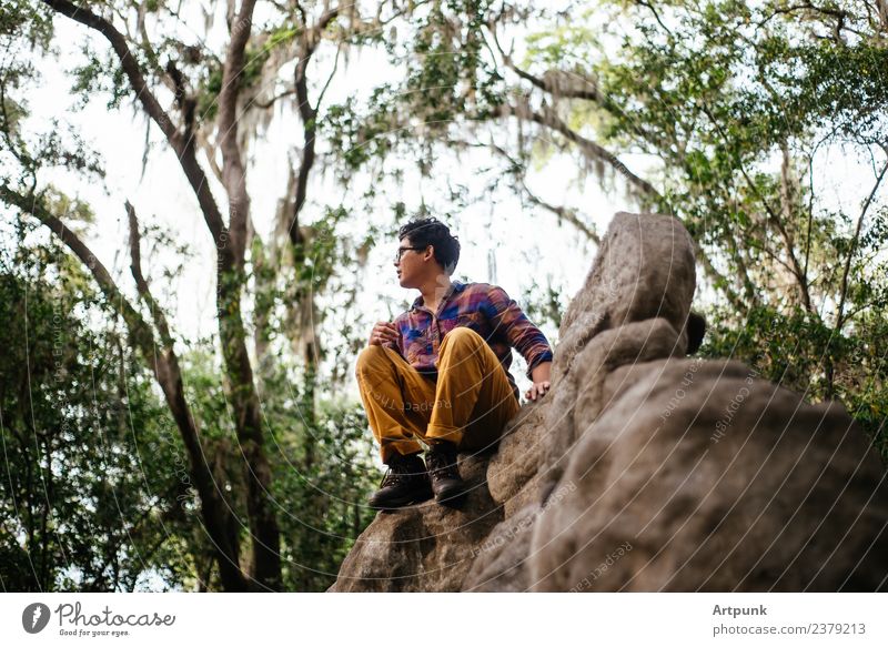 A young man perched on top of a booulder Stone block Exterior shot Camping Hiking Climbing Boots Forest Rock Sit Nature Adventure Vacation & Travel Tree Leaf