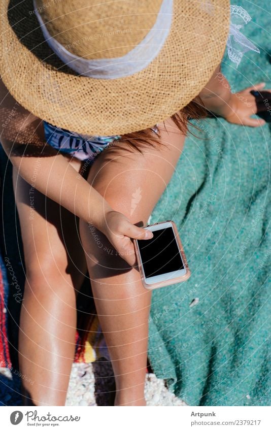 A young woman texting on the beach Beach Youth (Young adults) 18 - 30 years Young woman Woman Legs Hat Blanket Towel PDA Technology Exterior shot wifi Data
