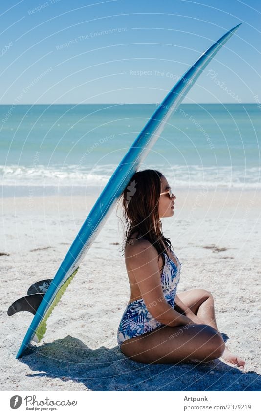 A young woman sitting under a surfboard 18 - 30 years Woman Latin American South America Asians Summer Surfboard Beach Sand Sun Ocean Water Bikini Long-haired