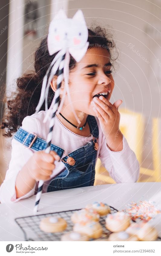 african little girl is eating selfmade cookies at home Dessert Lifestyle Joy Happy Beautiful Table Kitchen Child Human being Woman Adults Infancy Smiling
