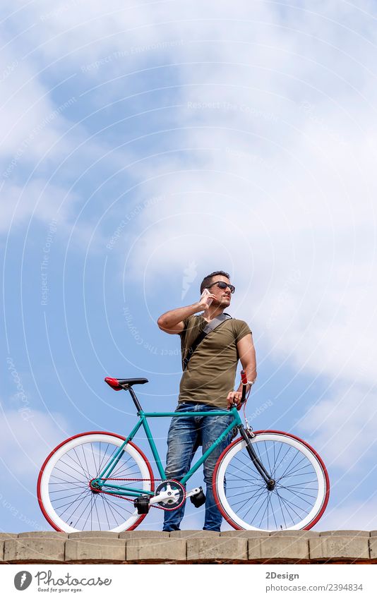 Young man standing outdoors and calling on the phone Lifestyle Style Vacation & Travel Cycling Business To talk Telephone Technology Human being Masculine