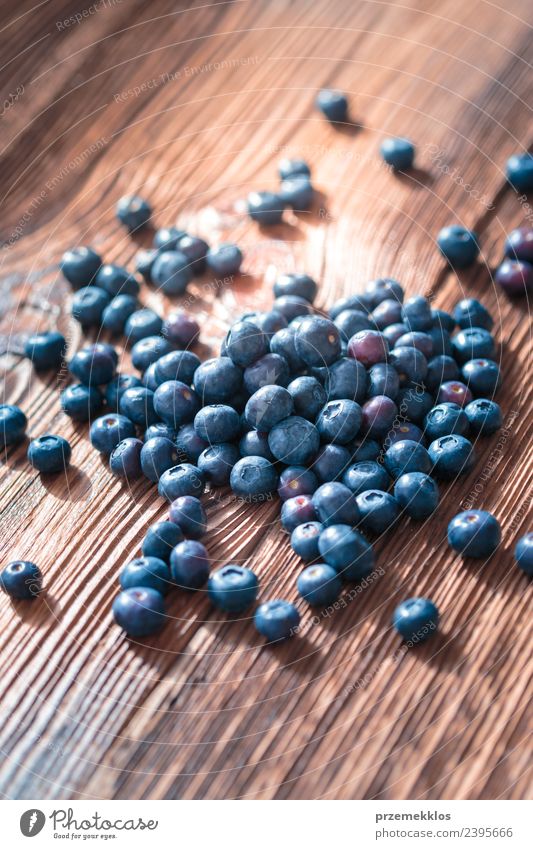 Freshly gathered blueberries scattered on old wooden table Fruit Nutrition Organic produce Vegetarian diet Bowl Summer Table Nature Wood Delicious Natural Juicy
