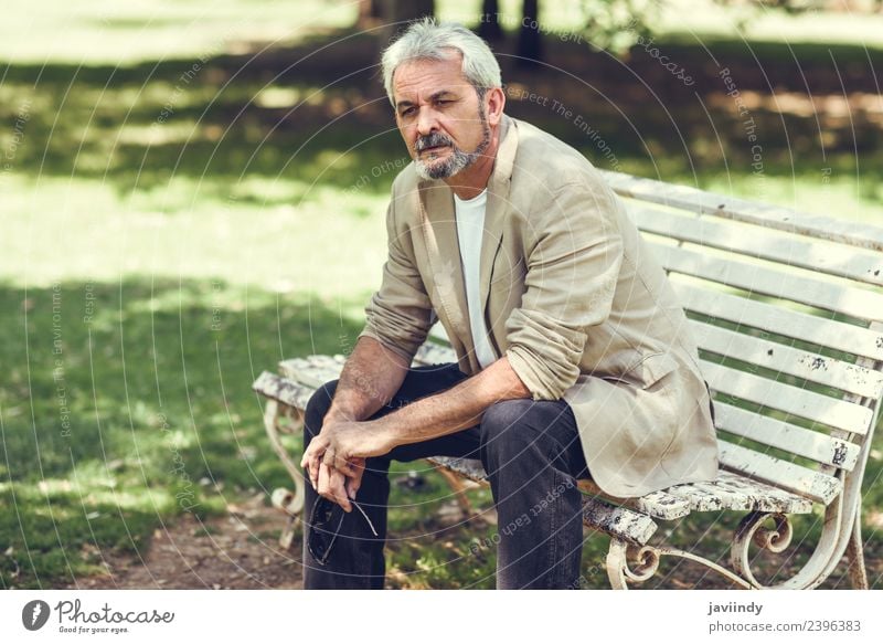 Pensive mature man sitting on a bench in an urban park. Lifestyle Happy Retirement Human being Masculine Man Adults Male senior Senior citizen 1 45 - 60 years