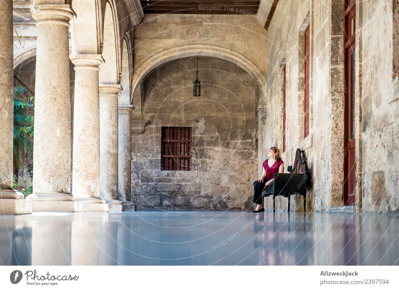 Young woman sitting on a bench in the courtyard of an old building Cuba Havana Column 1 Person Sit Relaxation Break Restful Bench To enjoy Calm Wall (barrier)