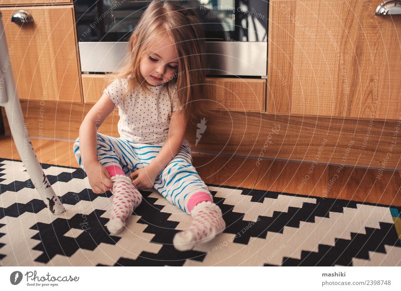 cute toddler girl put on socks at home Breakfast Lifestyle Joy Happy Beautiful Playing Kitchen Child Baby Woman Adults Infancy Clothing Sit Happiness Small