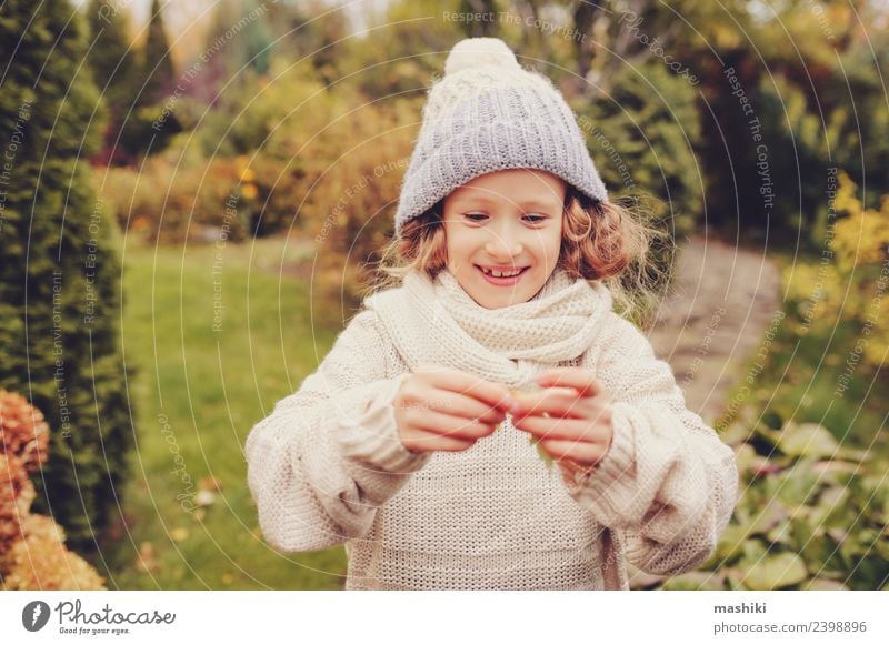 cute happy kid girl playing on autumn walk Joy Playing Vacation & Travel Garden Child Work and employment Nature Autumn Warmth Flower Leaf Sweater Scarf Smiling