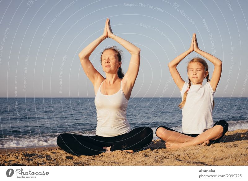Mother and daughter doing yoga exercises on the beach. - a Royalty Free  Stock Photo from Photocase