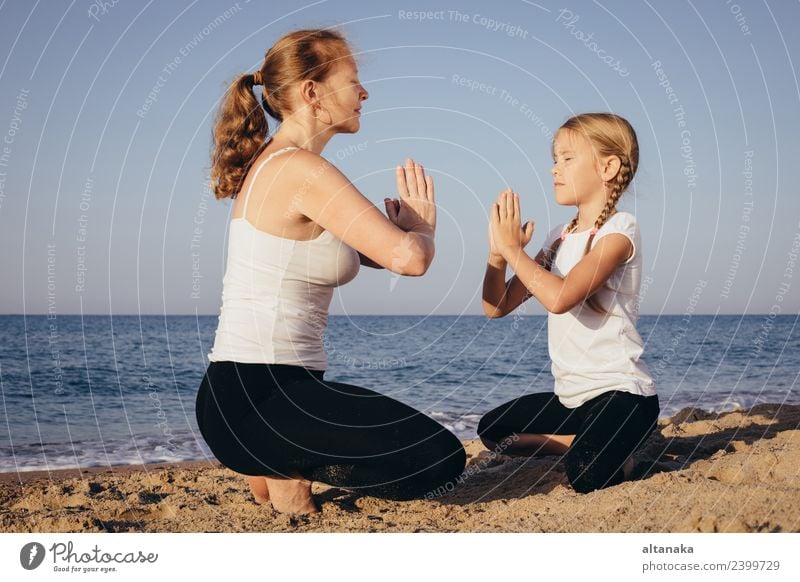 Mother and daughter doing yoga exercises on the beach. - a Royalty Free  Stock Photo from Photocase
