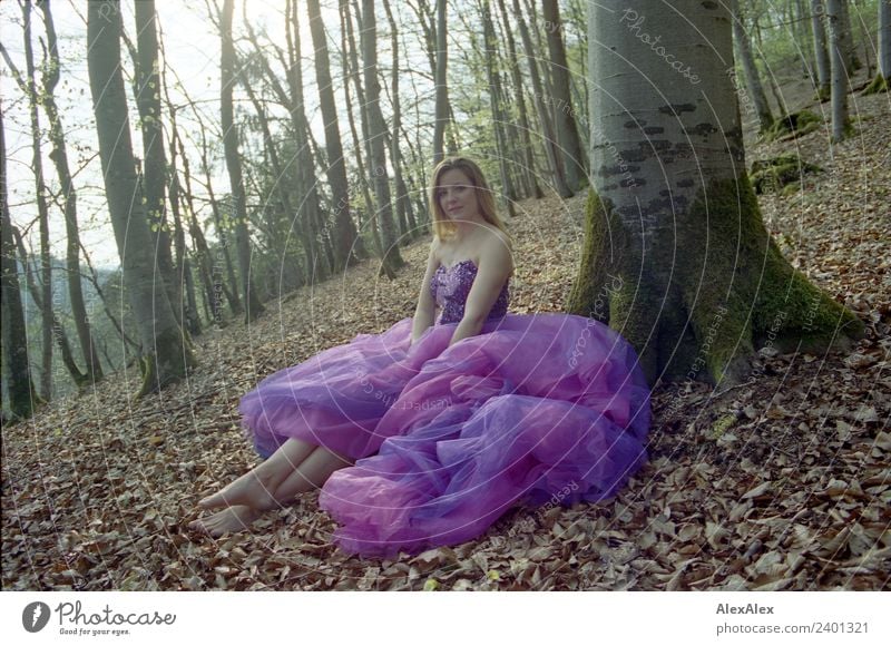 Young tall woman sitting barefoot by tree in forest in purple wedding dress Lifestyle Luxury Elegant Style Joy pretty Relaxation Trip Summer Young woman