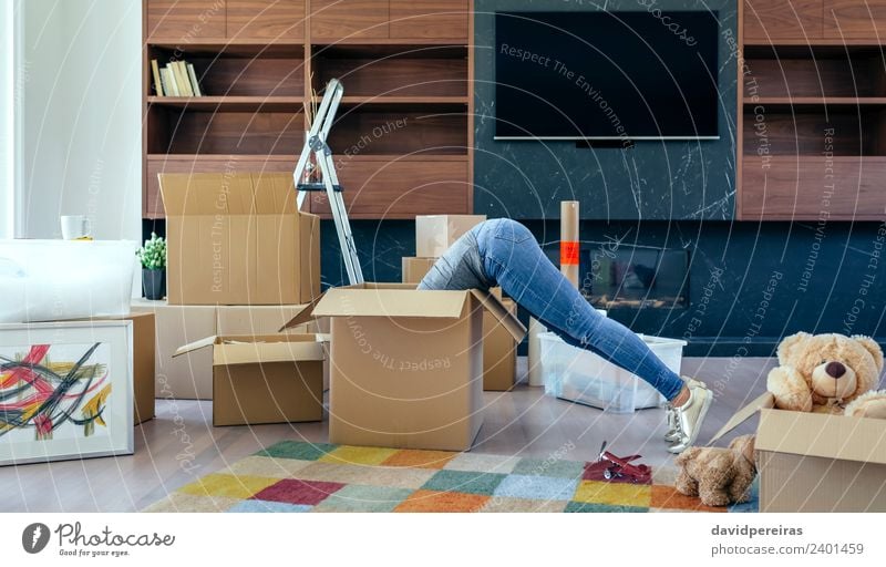 Woman inside a box preparing the move Lifestyle House (Residential Structure) Moving (to change residence) Living room Human being Adults Jeans Sneakers Toys