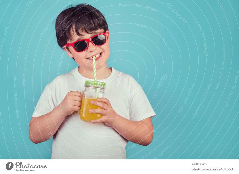 happy boy drinking orange juice on blue background Nutrition Beverage Drinking Lemonade Juice Lifestyle Joy Human being Masculine Child Toddler Infancy 1