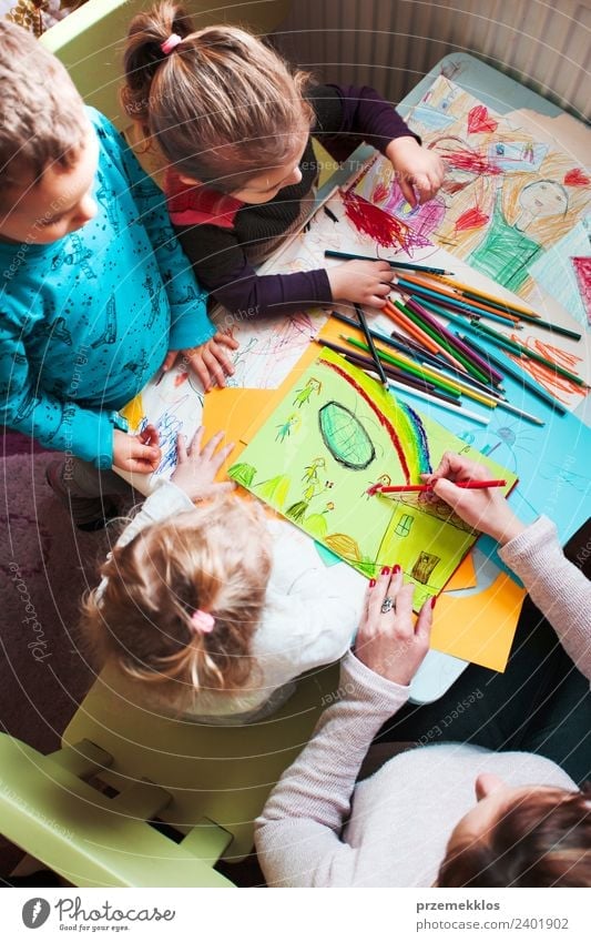 Kids drawing of family and colored pencils on wooden table Stock Photo -  Alamy