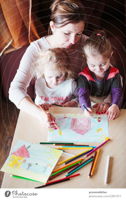 Mom with little girls drawing a colorful picture Lifestyle Joy Happy Handcrafts Table Parenting Education Kindergarten Child School Human being Girl Parents