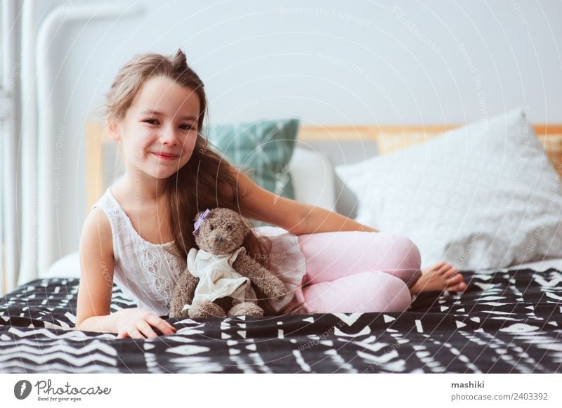 cute happy child girl relaxing at home on the bed Lifestyle Joy Relaxation Child Toys Teddy bear Smiling Sleep Dream Small Funny Cute Energy kid Wake up healthy