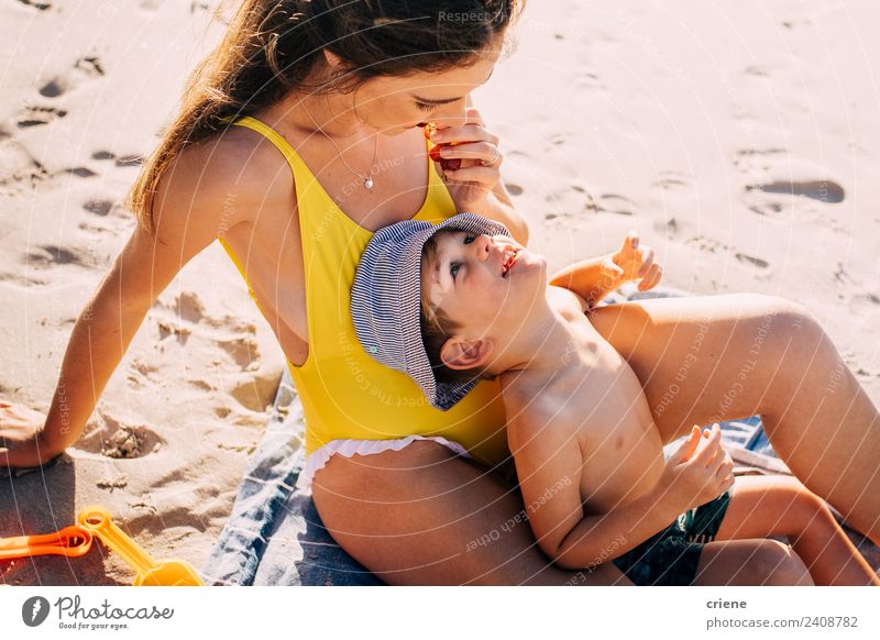 happy caucasian mum and his son eating some fuits at the beach Fruit Nutrition Happy Beach Child Toddler Woman Adults Mother Family & Relations Sand Hat