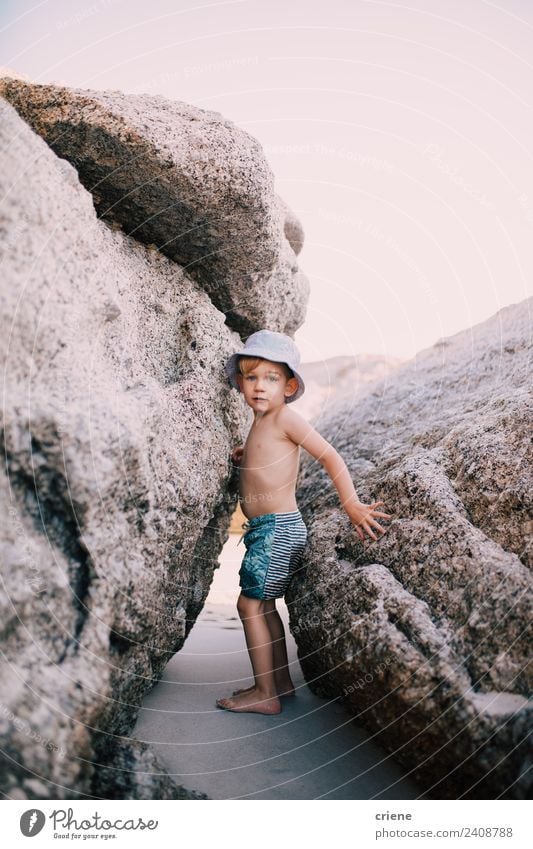 little caucasian boy climbing between big rocks at the beach Summer Beach Climbing Mountaineering Child Toddler Boy (child) Infancy Warmth Rock Swimming trunks