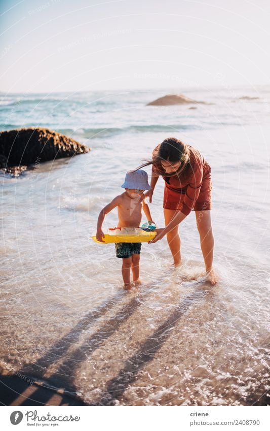 mother and son having fun with inflatable ring at beach Lifestyle Joy Happy Leisure and hobbies Playing Vacation & Travel Sun Beach Ocean Child Boy (child)