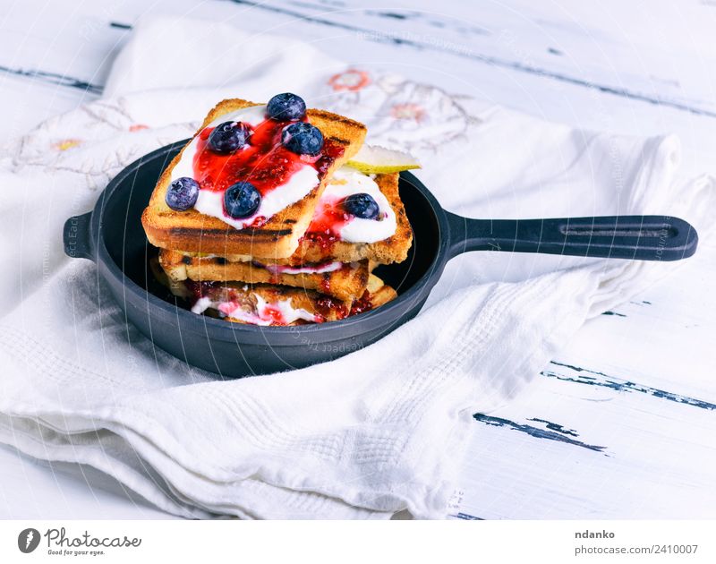 French toast with berries Fruit Bread Dessert Candy Breakfast Pan Table Fresh Delicious White french cream food background Cast iron vintage Rustic Pear Syrup