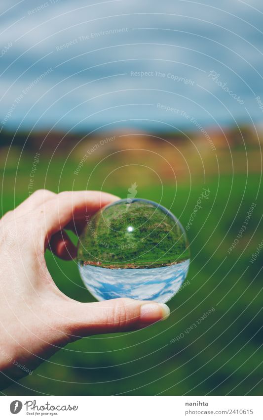 Beautiful and green landscape view through a crystal ball Hand Environment Nature Landscape Sky Spring Summer Beautiful weather Grass Field Crystal ball Glass