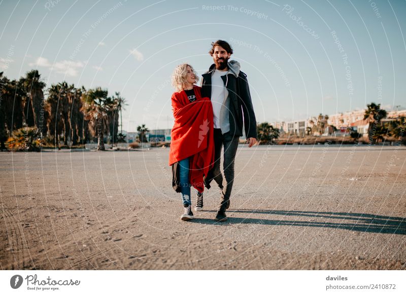 Blonde woman and bearded man taking a walk embraced outdoors at sunset. Lifestyle Joy Sun Winter Woman Adults Man Couple Beard Smiling Love Embrace Cool (slang)