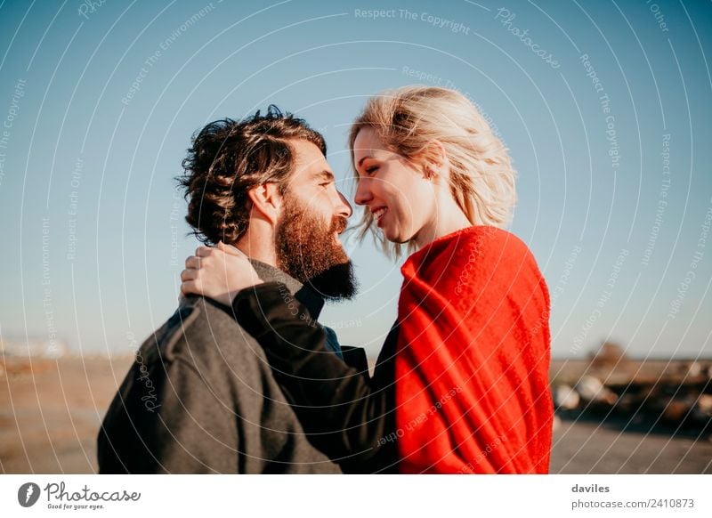 Bearded man and blonde woman looking to each. Lifestyle Joy Happy Beautiful Sun Winter Woman Adults Man Couple Fashion Blonde Kissing Smiling Love Embrace